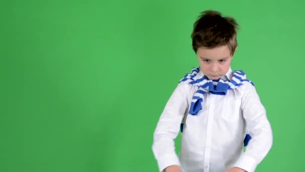 Young handsome child boy adjusts his clothes and smiles to camera - green screen - studio — Stock Video