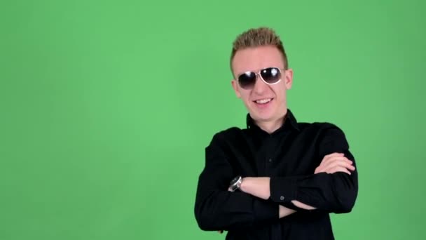 Young handsome man with sunglasses (grimaces) - green screen - studio — Stock Video