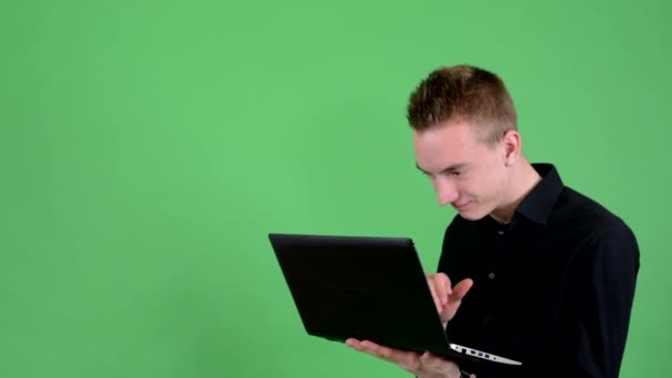 Jonge knappe man werkt op computer (laptop) - schadelijke - groene scherm - studio — Stockvideo