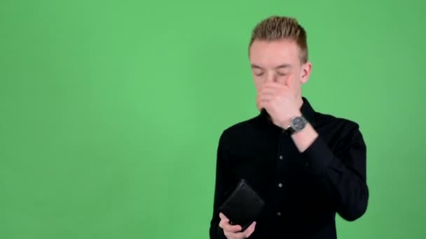 Joven hombre guapo mira a la cartera y tienen depresión - pantalla verde - estudio — Vídeos de Stock