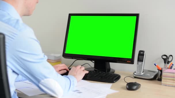 Uomo lavora sul computer desktop in ufficio - schermo verde — Video Stock