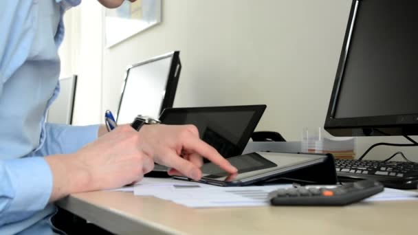 Junger gutaussehender Mann arbeitet im Büro (schreibt und arbeitet am Tablet) - Nahaufnahme — Stockvideo