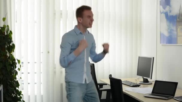 Jonge knappe man verheugt zich in het kantoor — Stockvideo
