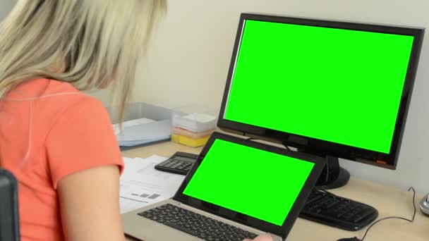 Giovane donna attraente guarda sul computer portatile e fatto col personal computer nell'ufficio - lo schermo verde — Video Stock