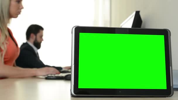 Tablet - Green Screen - Mann und Frau arbeiten am Computer im Büro im Hintergrund — Stockvideo