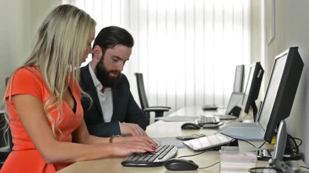 Mujer y hombre juntos trabajan en la computadora de escritorio en la oficina (trabajadores) - jefe y secretario — Vídeos de Stock