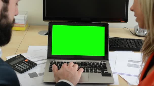 L'uomo e la donna insieme lavorano sul computer portatile in ufficio - lo schermo verde — Video Stock
