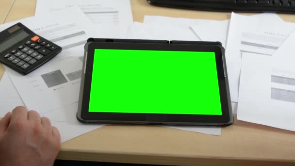 Άνθρωπος και γυναίκα εργάζονται για το δισκίο στο γραφείο (έγγραφα και αριθμομηχανή)-πράσινη οθόνη-κοντινά πλάνα (μόνο τα χέρια) — Αρχείο Βίντεο