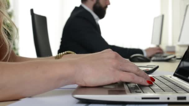 Vrouw werkt op laptop en man werkt op desktop computer in het kantoor (arbeiders) — Stockvideo