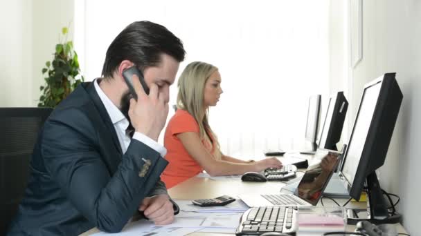 Man phone and woman works on desktop computer in the office (workers) — Stock Video