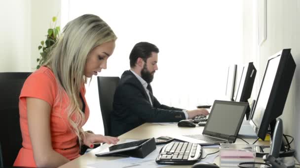 여자는 태블릿으로 일하고 남자는 사무실에서 데스크 탑 컴퓨터로 일한다 ( 근로자들 )) — 비디오