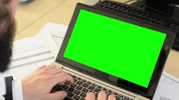 Jonge knappe man met full-bard (hipster) werkt op laptop in het kantoor - computer — Stockvideo