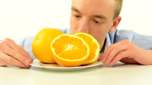 Homme regarde orange et s'en va - fruits - fond blanc studio — Video