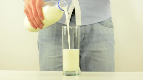 Man giet melk in een glas-witte achtergrond Studio — Stockvideo