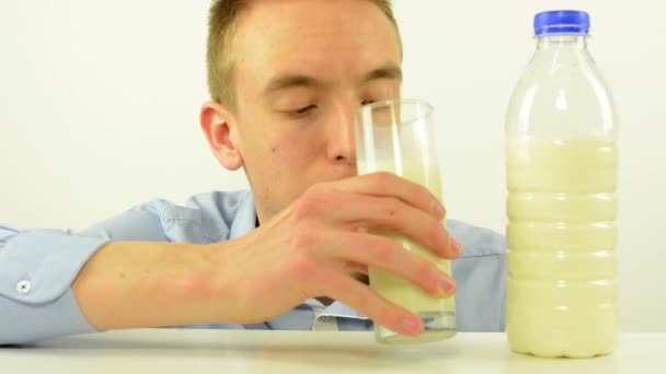 Junger Mann trinkt Milch - weißer Hintergrund Studio — Stockvideo