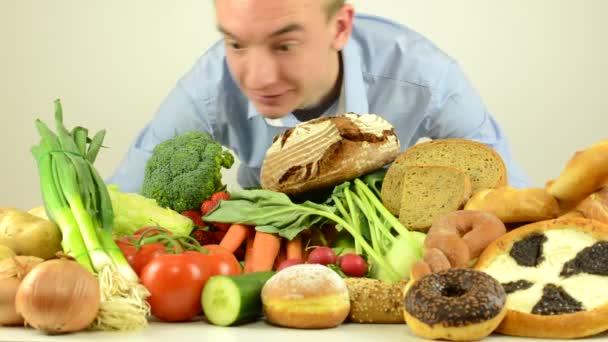 Man smells to food - vegetables, fruits and bakery products - white background studio — Stock Video