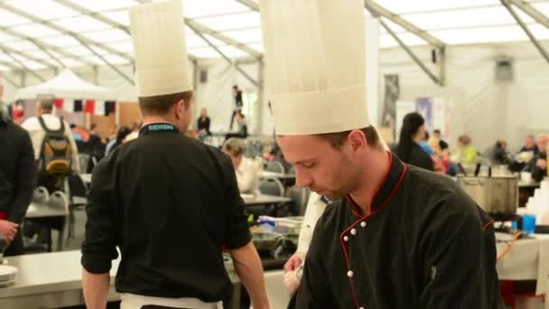 PRAGUE, CZECH REPUBLIC - MAY 2, 2015: chefs and waiters talks - closeup head - people in restaurant (exhibition) in background — Stock Video