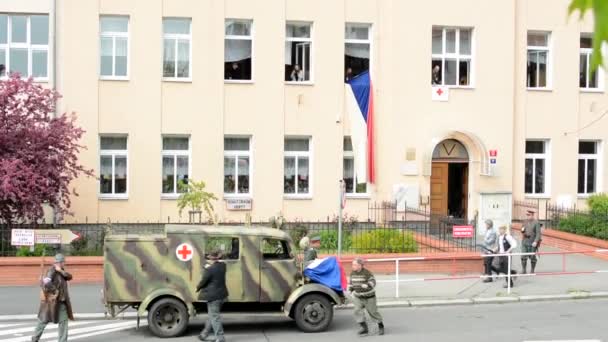 Prag, Tjeckien-maj 2, 2015: reenactment Performance slaget vid andra världskriget på gatan-ambulans driver en sårad man-sjukvårdare och soldater — Stockvideo