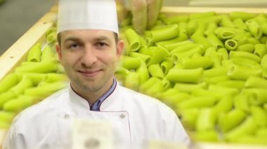 şef kameraya gülümsüyor - rafta kurutulmuş makarna - şef makarna kalitesini kontrol eder - ellerde closeup