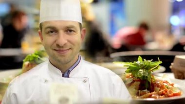 şef kameraya gülümsüyor - yemekler (yemek: makarna) servise hazır