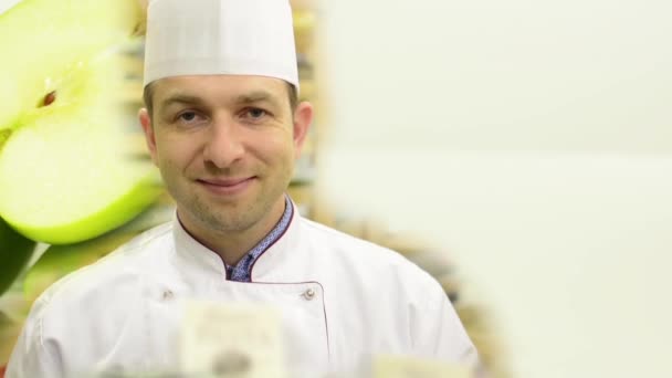 Chef sonríe a la cámara - frutas - manzanas verdes - estudio de fondo blanco — Vídeos de Stock