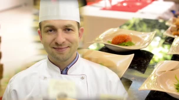 Chef sorri para a câmera - comida cozida na cozinha (salmão) - pronta para o serviço — Vídeo de Stock