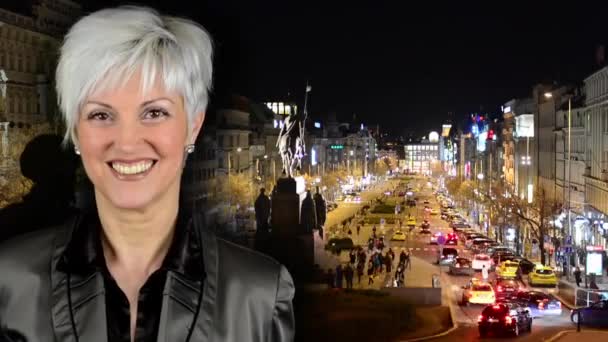 Business middle aged woman smiles - night Wenceslas Square with people and passing cars - buildings - timelapse — Stock Video