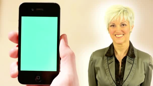 Business medelålders kvinna Smiles-hand (ung man) innehar en smartphone-grön skärm — Stockvideo