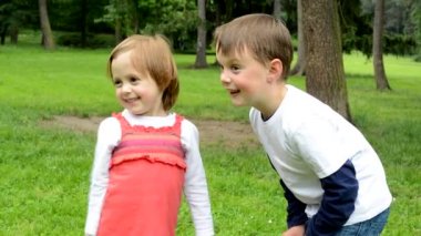 çocuklar (kardeşler - küçük erkek ve sevimli kız) parkta konuşmak