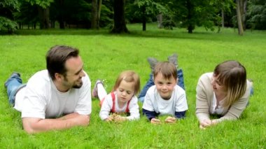 aile (aşık orta yaşlı çift, erkek ve kız) çim ve kameraya gülümseme yalan