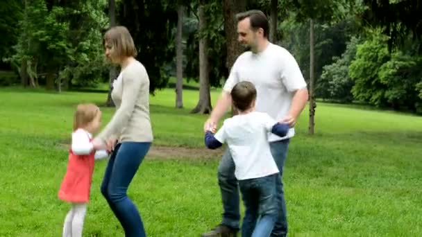 Rodina (blízký pár zamilovaní, roztomilá holčička a malý chlapeček) tančí v parku — Stock video