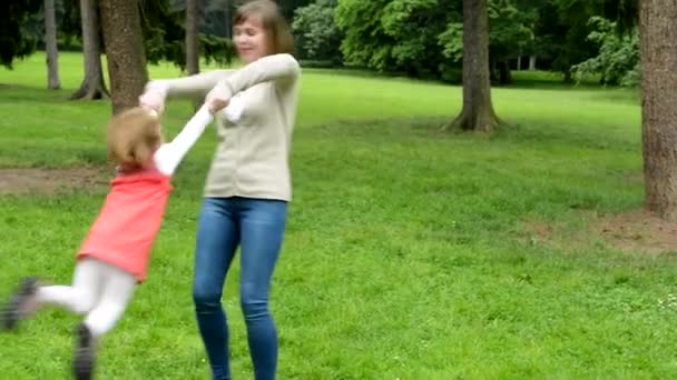 Мать с дочкой (симпатичная девочка) кружатся вокруг - парк — стоковое видео