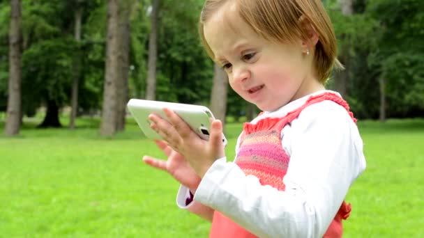jeune petite fille travaille sur smartphone - parc 