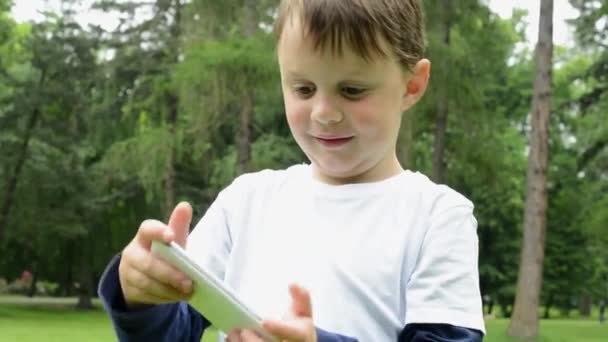 jeune garçon joue à des jeux sur smartphone - parc 