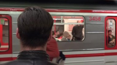 Genç yakışıklı hippi tren istasyonunda bekliyor ve tren istasyonundan ayrılan adamı izliyor.