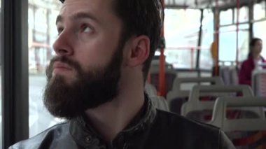 genç yakışıklı hipster adam seyahat tramvay ve pencere - insanlarla sokak - closeup dışında görünüyor