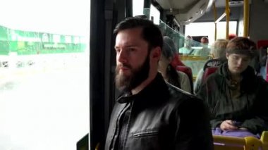 Prag, Çek Cumhuriyeti - 30 Mayıs 2015: genç yakışıklı hipster adam arka planda diğer insanlarla otobüsle seyahat - şehirde kentsel sokak