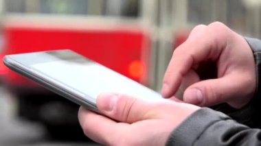 adam tabletüzerinde (yazarak) çalışır - şehir - geçen araba ile kentsel sokak - closeup