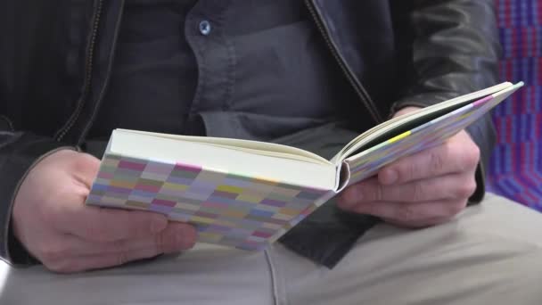 Mann liest ein Buch - Innenraum - Nahaufnahme Buch — Stockvideo