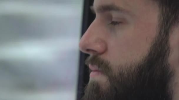 Joven hombre hipster guapo que viaja en transporte público y mira por la ventana - primer plano — Vídeos de Stock