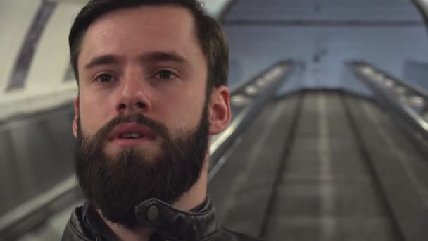 Jonge knappe hipster man reist op de roltrap in de metro — Stockvideo