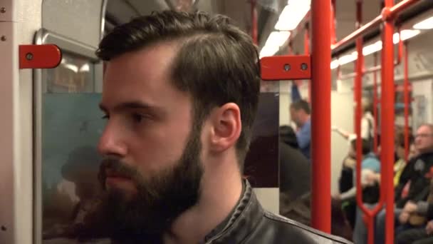 Joven hombre hipster guapo viajando en metro - otras personas en el fondo — Vídeos de Stock