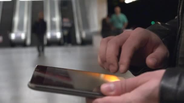 Jonge knappe hipster man werkt op tablet - metrostation (roltrappen) - close-up — Stockvideo