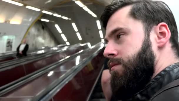 年轻英俊的嬉皮士在地铁的自动扶梯上旅行- -其他人 — 图库视频影像