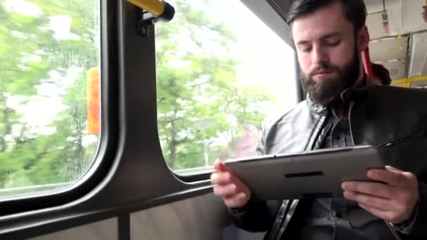 Joven guapo hipster hombre viajar en tranvía y obras en tableta — Vídeo de stock