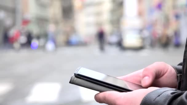 Man works (typing) on smartphone - city - urban street - close seup hand — стоковое видео