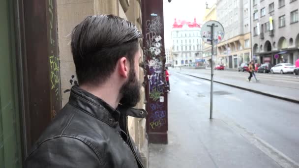 Jonge knappe hipster man wachten op de stedelijke straat en kijkt rond - stad (lelijke straat) — Stockvideo