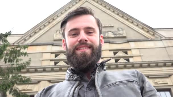 Jeune homme hipster beau sourire à la caméra - bâtiment (université) en arrière-plan - prise de vue d'en bas — Video