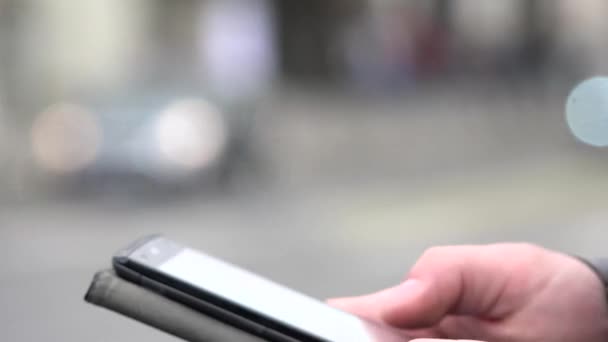 Uomo lavora (digitando) su smartphone - città - strada urbana - primo piano — Video Stock