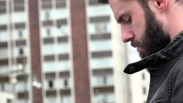 Young handsome hipster man works (typing) on smartphone - city - urban street - closeup — Stock Video